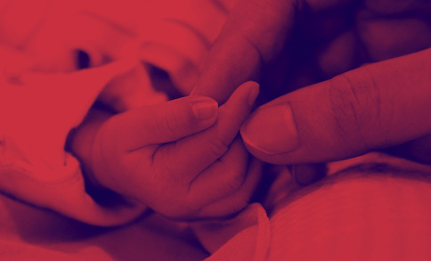 Hands of a woman and a newborn